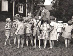 Pastor Lund som besöker Birkagårdsbarnen på Nyckelbäcken 1935.
